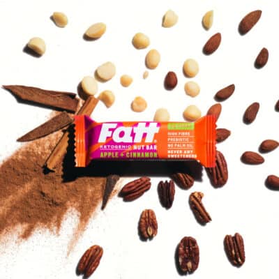 Fatt - Apple + Cinnamon bar on a white background with cinnamon, apple and almonds spread out behind it