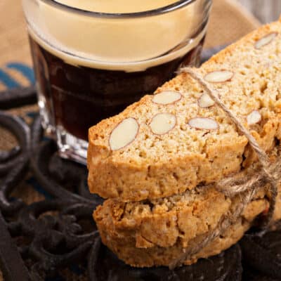 a stack of keto biscotti tied with a string with a cup of coffee