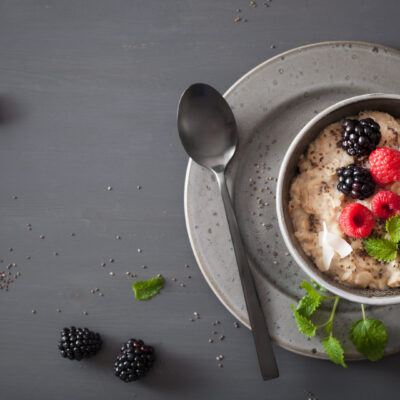 keto porridge in a grey bowl with raspberries, blackberries and a mint leaf