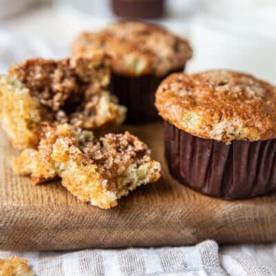 two Low Carb Apple Breakfast Muffin, one broken apart on a chopping board