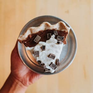 a hand holding one slice of low-carb french silk pie in a bowl