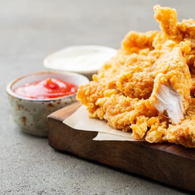 Low-carb chicken nuggets on a chopping board with low-carb tomato ketchup for serving
