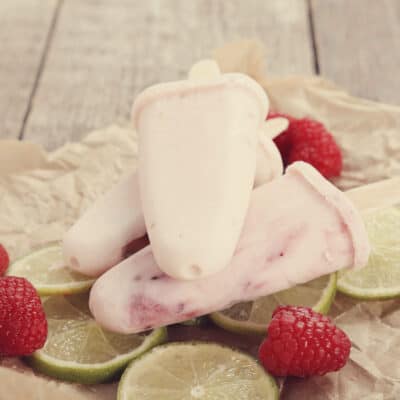 low-carb frozen yoghurt popsicles with raspberries and slices of lime