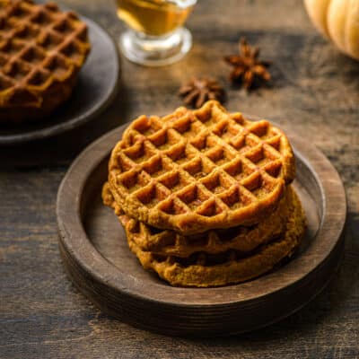 stack of 3 pumpkin waffles on a dark wooden table