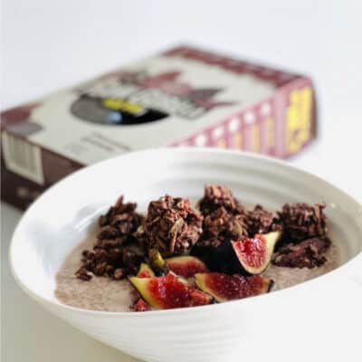 raw gorilla chocolate granola in a white bowl with yoghurt and figs.